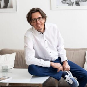 Man in witte blouse op bank